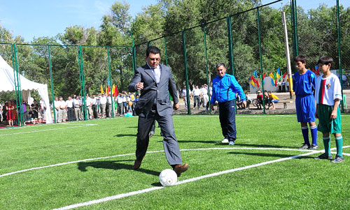 Аким Канат Бозумбаев наносит удар по мячу на новой футбольной площадке
